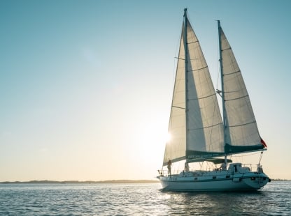 A boat is sailing at sunset.