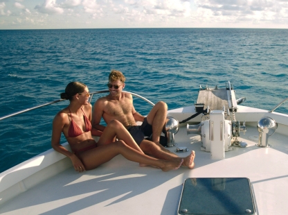 A couple is sitting on a boat smiling.