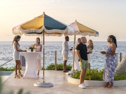 A group of people standing by the poolside.