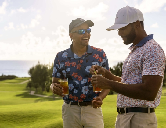 Two men enjoying a rum cocktail on the golf course.
