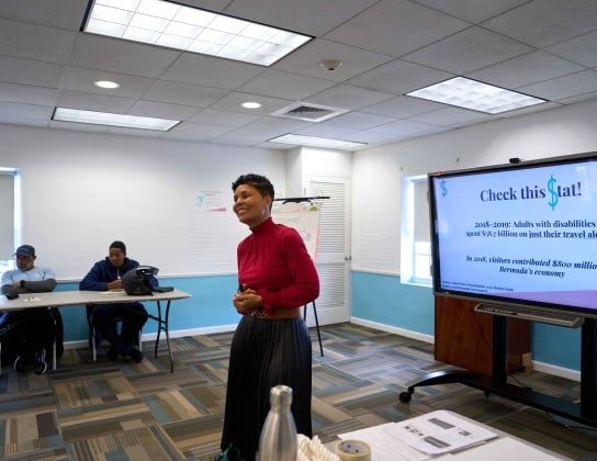 A woman is smiling teaching a class.