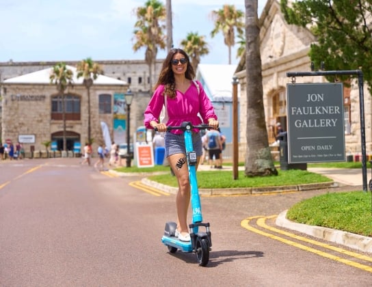 A woman is riding an electric scooter.