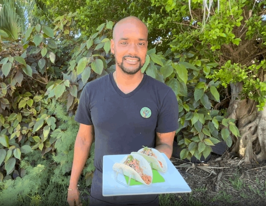 A man is holding vegan food on a plate.