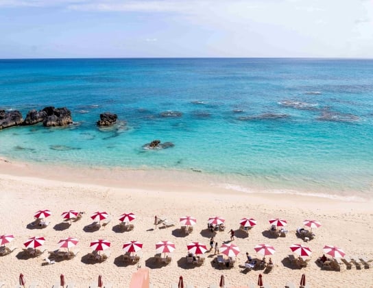 An aerial view of a hotel with beach chairs and umbrellas.