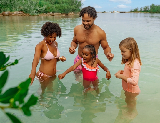 A family is in the water feeding fish.