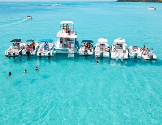 A group of boats and swimmers all together on the turquoise blue waters of Bermuda