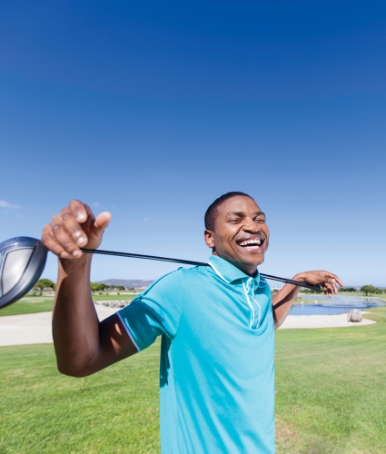 man holding a gold driver across his sholders