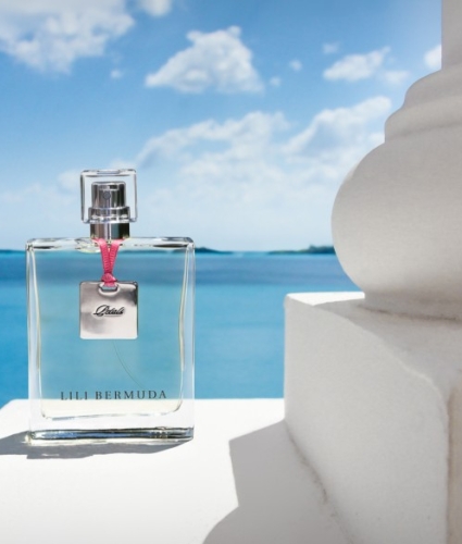 bottle of perfume infront of ocean