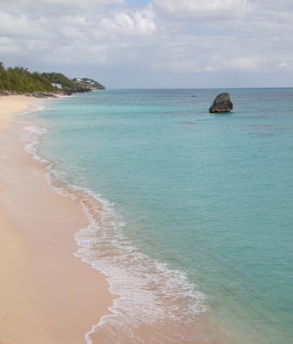 A pink sand beach with turquoise waters.