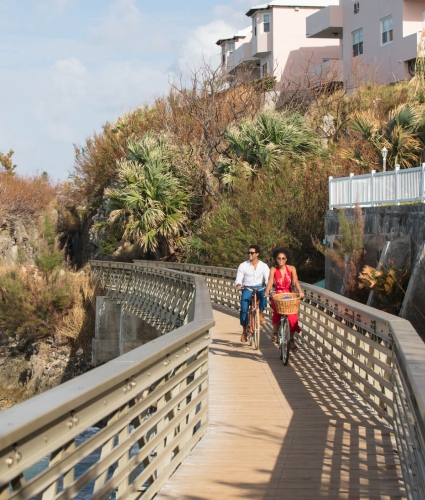 couple biking along a coastal section of the railway trail