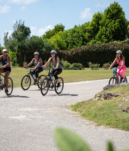 women biking through park