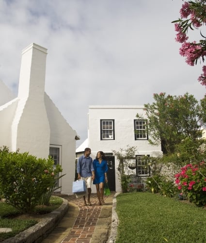 A couple leaves a store with shopping bags in hand in St. George’s, Bermuda.