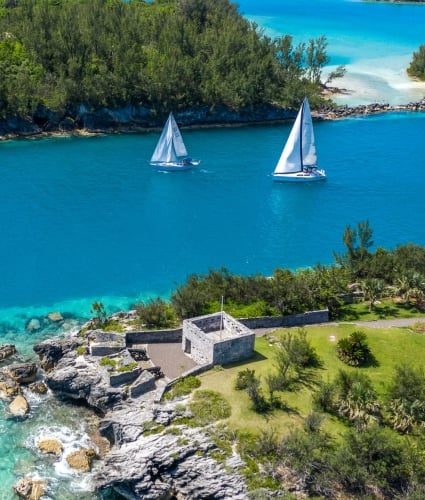 sail boats passing through a channel of water off of the coast of Bermuda