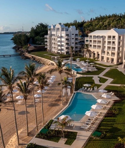 Aerial of St Regis Bermuda with two pools and an empty beach.