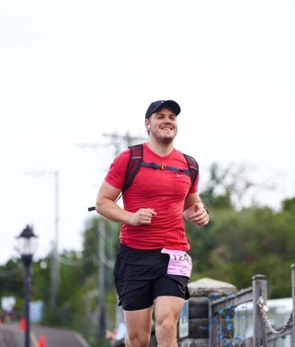 A man is running while smiling.