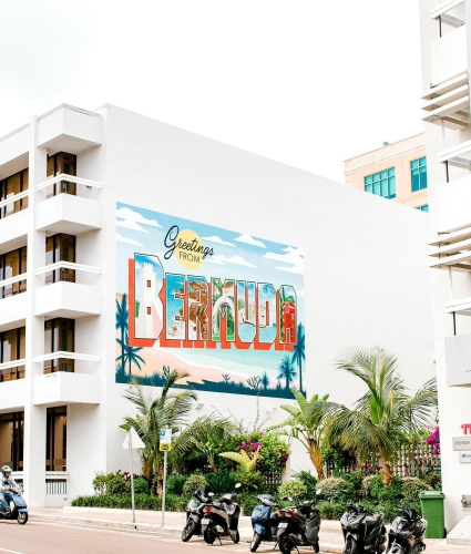 A sign painted on the side of a building that says "Greetings from Bermuda".