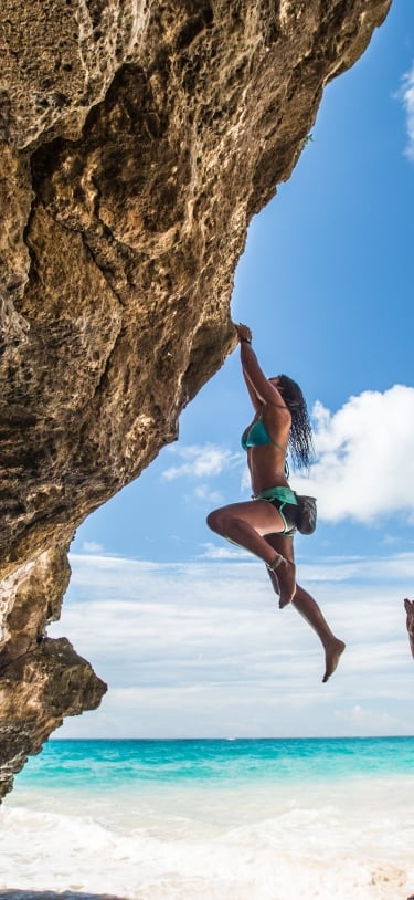 man spotting woman who is rock climbing