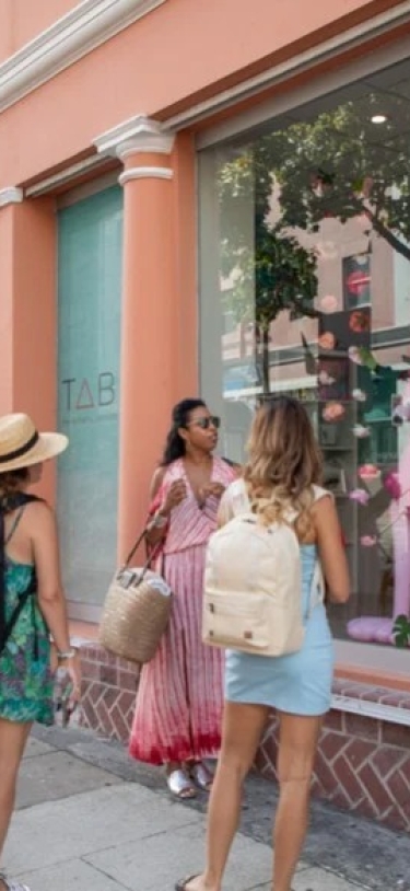 five women with backpacks window shopping