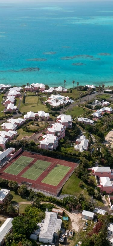 Aerial view of Cambridge Beaches with tennis courts, beach and boats.