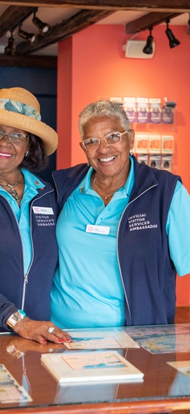 Two elderly women are smiling at the camera.