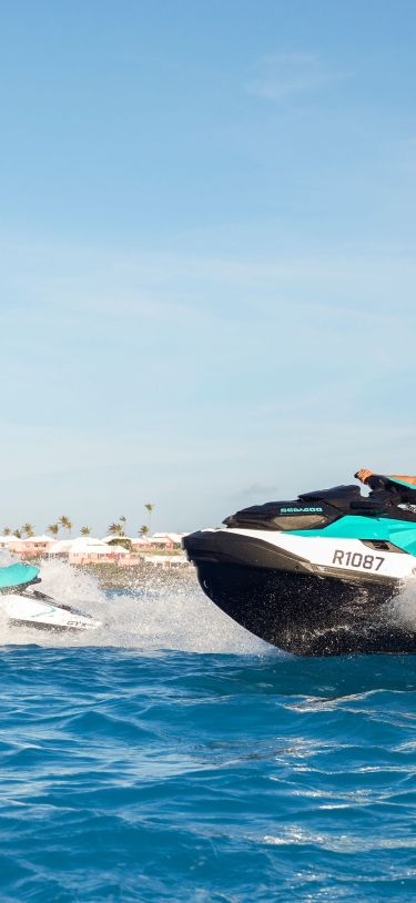 Two people jet skiing on the ocean.