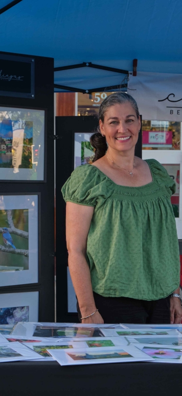 Two woman are smiling at the camera while at their photography booth.