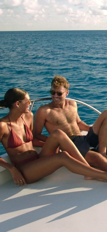 A couple is sitting on a boat smiling.