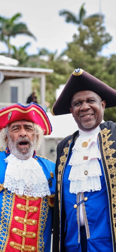 Bermudian tour guides in historical regalia welcome visitors.