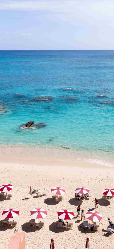 An aerial view of a hotel with beach chairs and umbrellas.