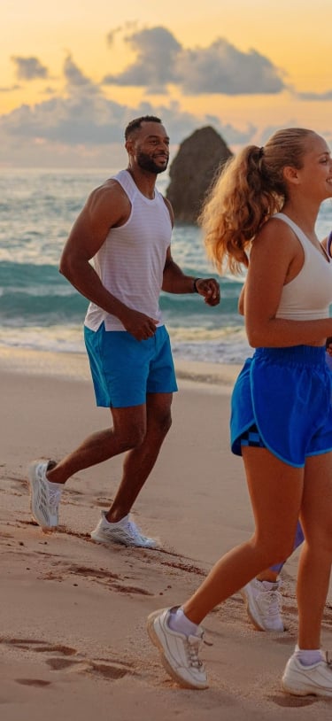 A group of friends are running on the beach.