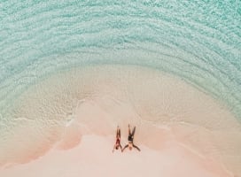 Two people laying on the beach