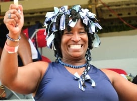 A woman is smiling at the camera in her Cup Match Colours.