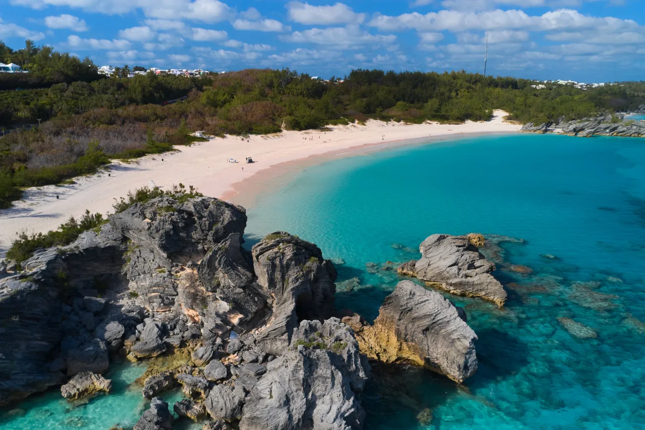 An aerial view of Horseshoe Bay with a rock outcropping into the blue waters, in Bermuda