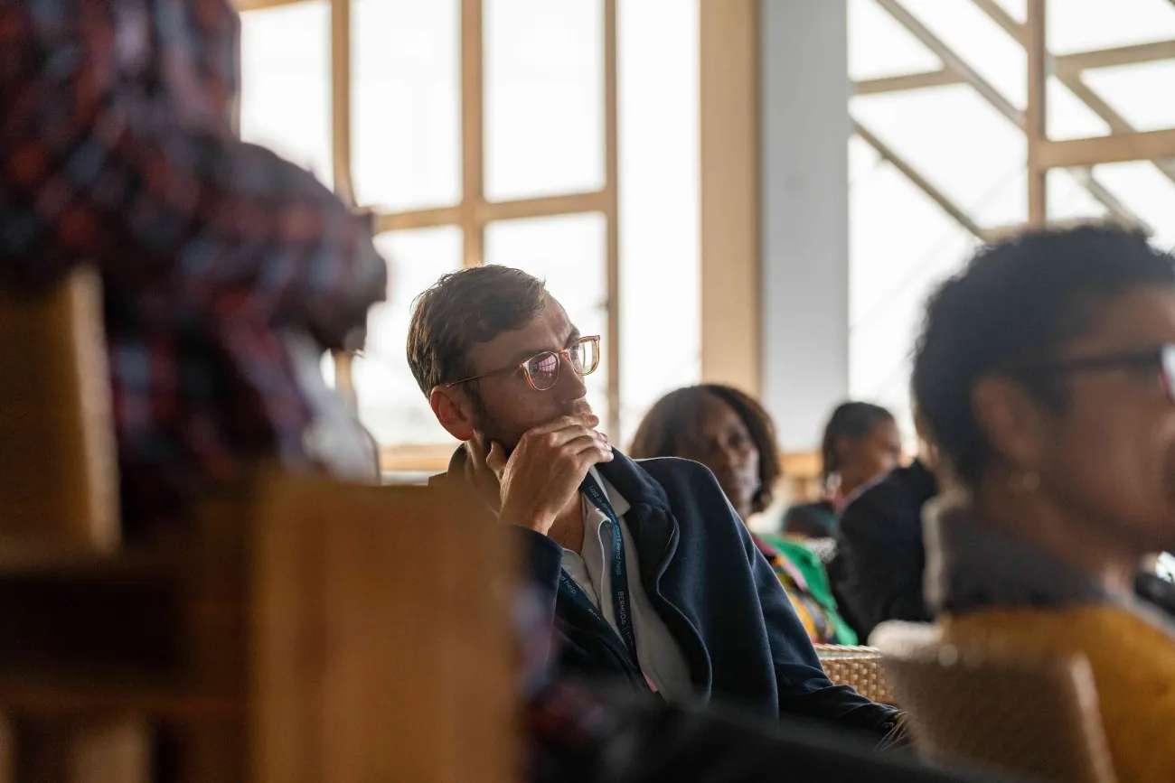A man listening to a speech at a Bermuda Tourism Summit event