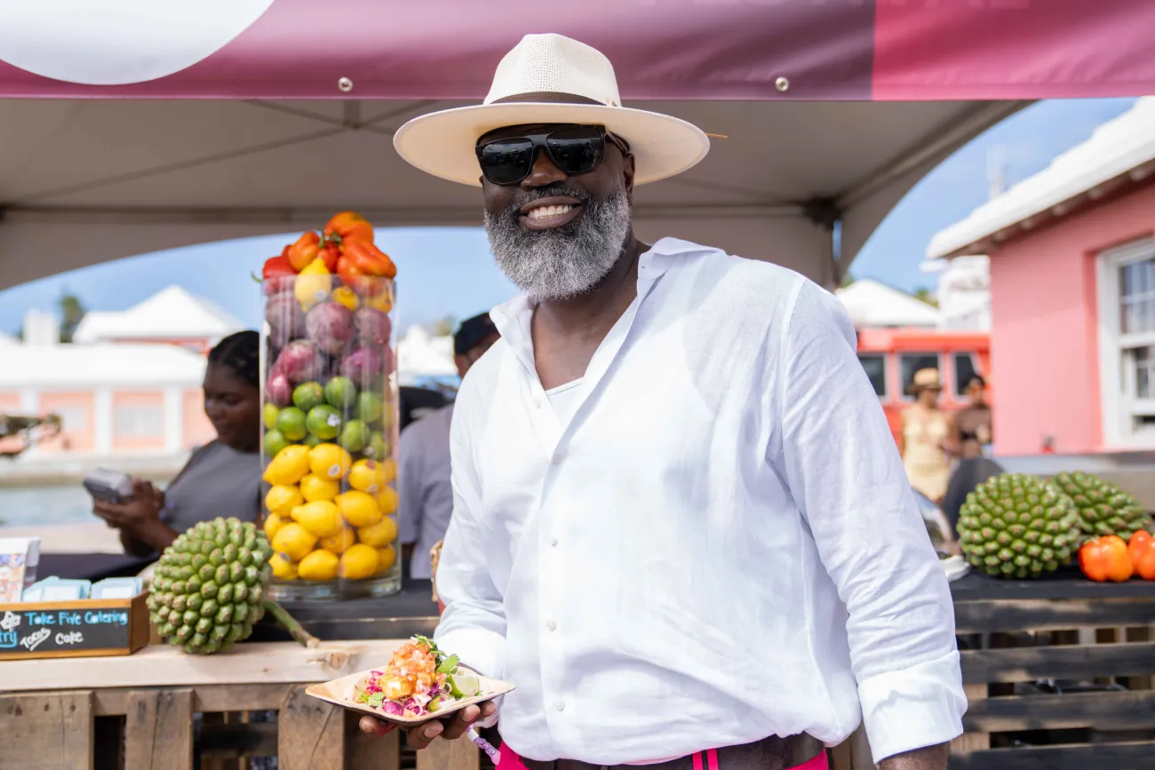 A man is posing while holding a plate of food.