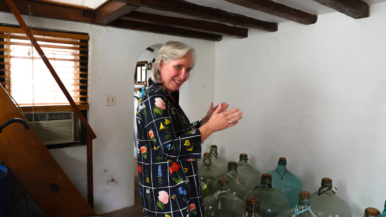 Isabel is in an old Bermuda building with her perfume bottles.
