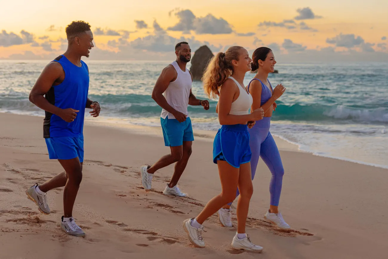 A group of friends are running on the beach.