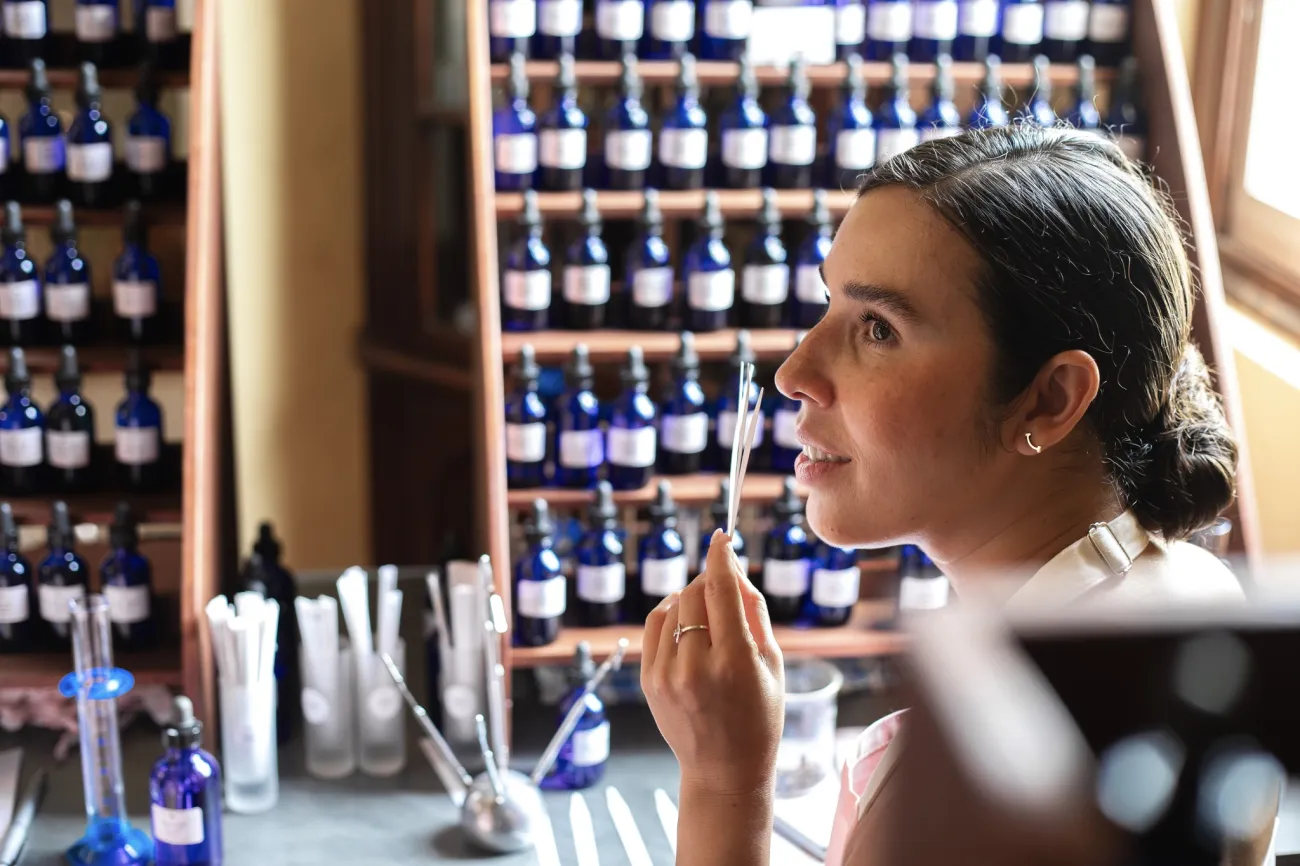 A woman is smelling fragrances