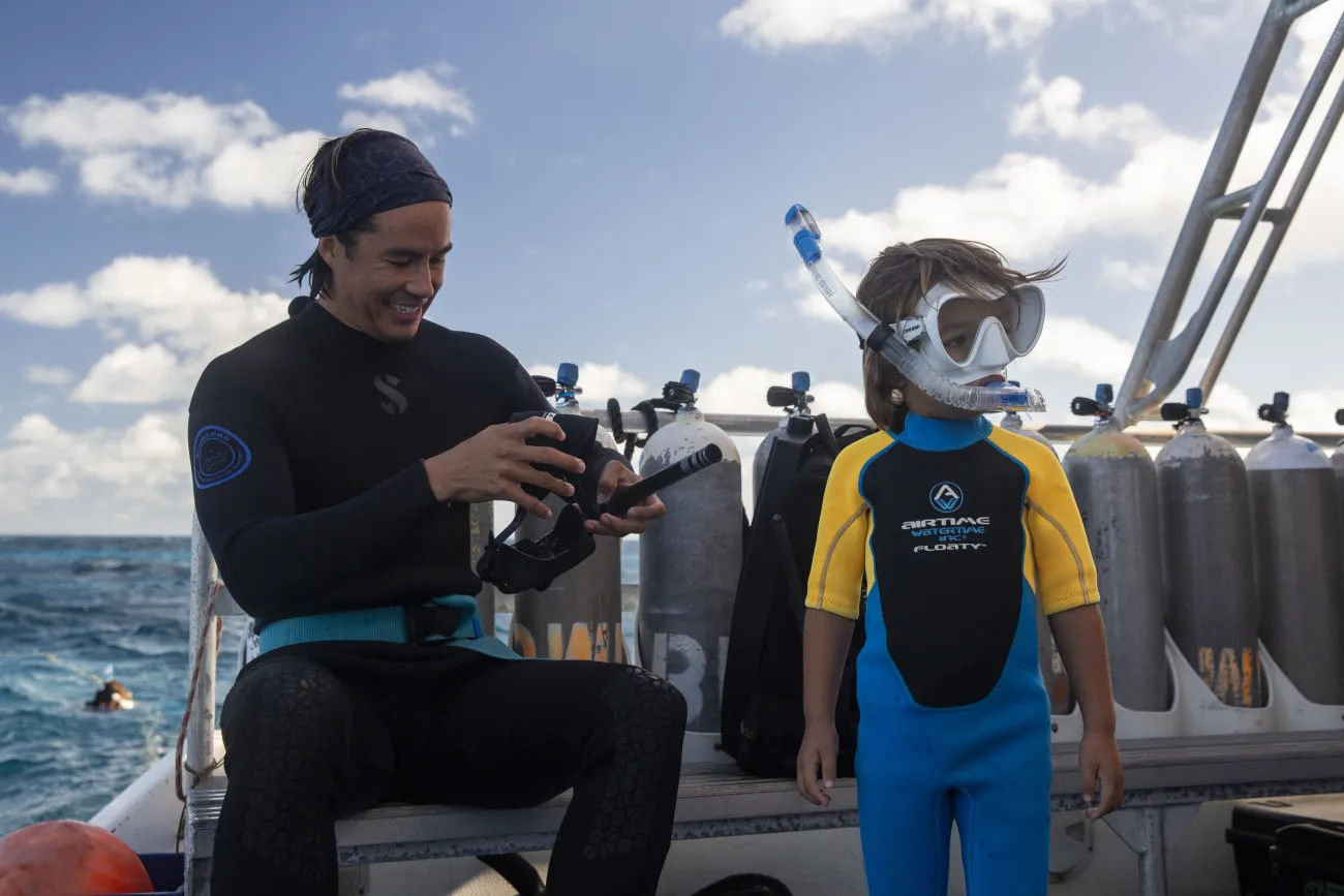 A dad and a son are getting ready to go snorkeling in Bermuda waters.