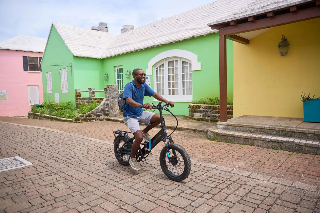 A guy is riding an electric bike down scenic St. George's.