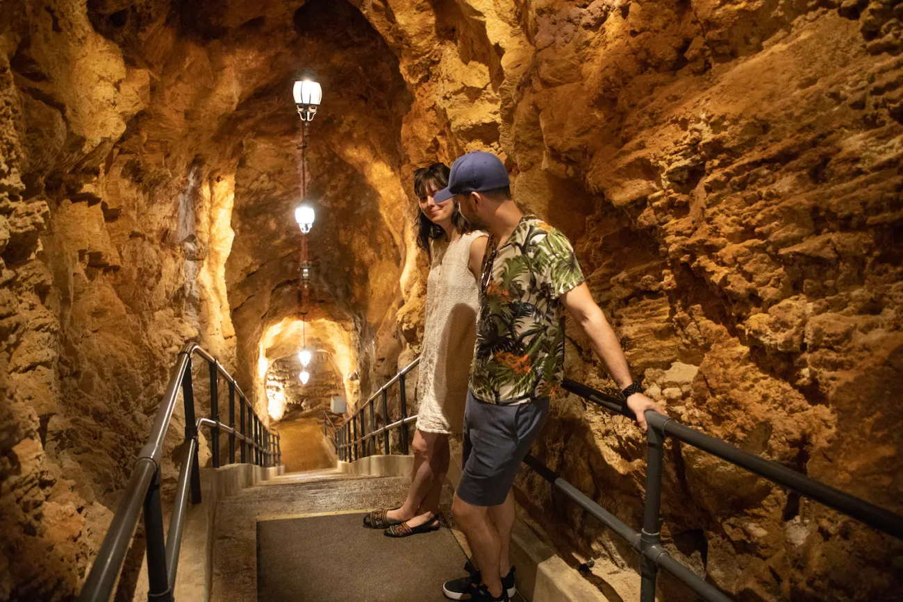 A couple walking through Crystal Caves in Bermuda