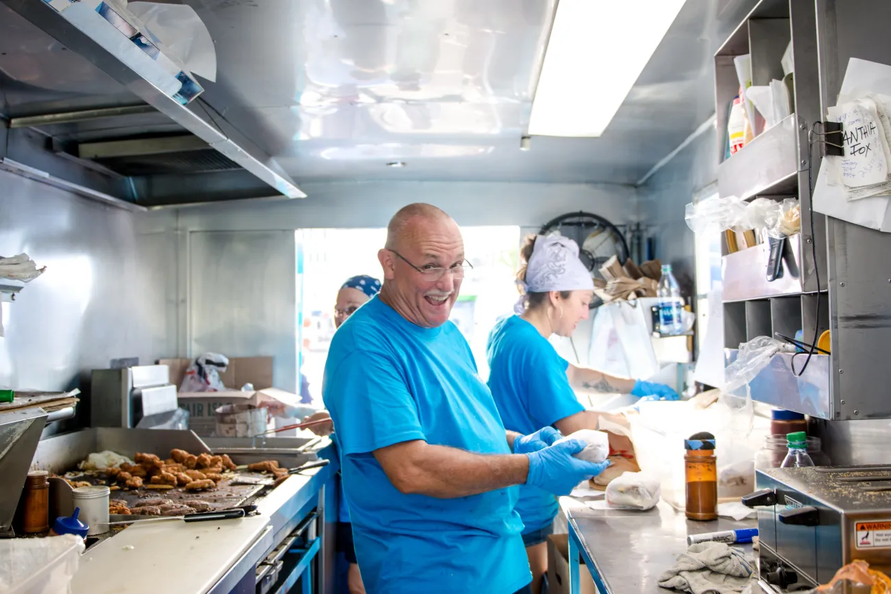 A group of people are cooking in a food truck.