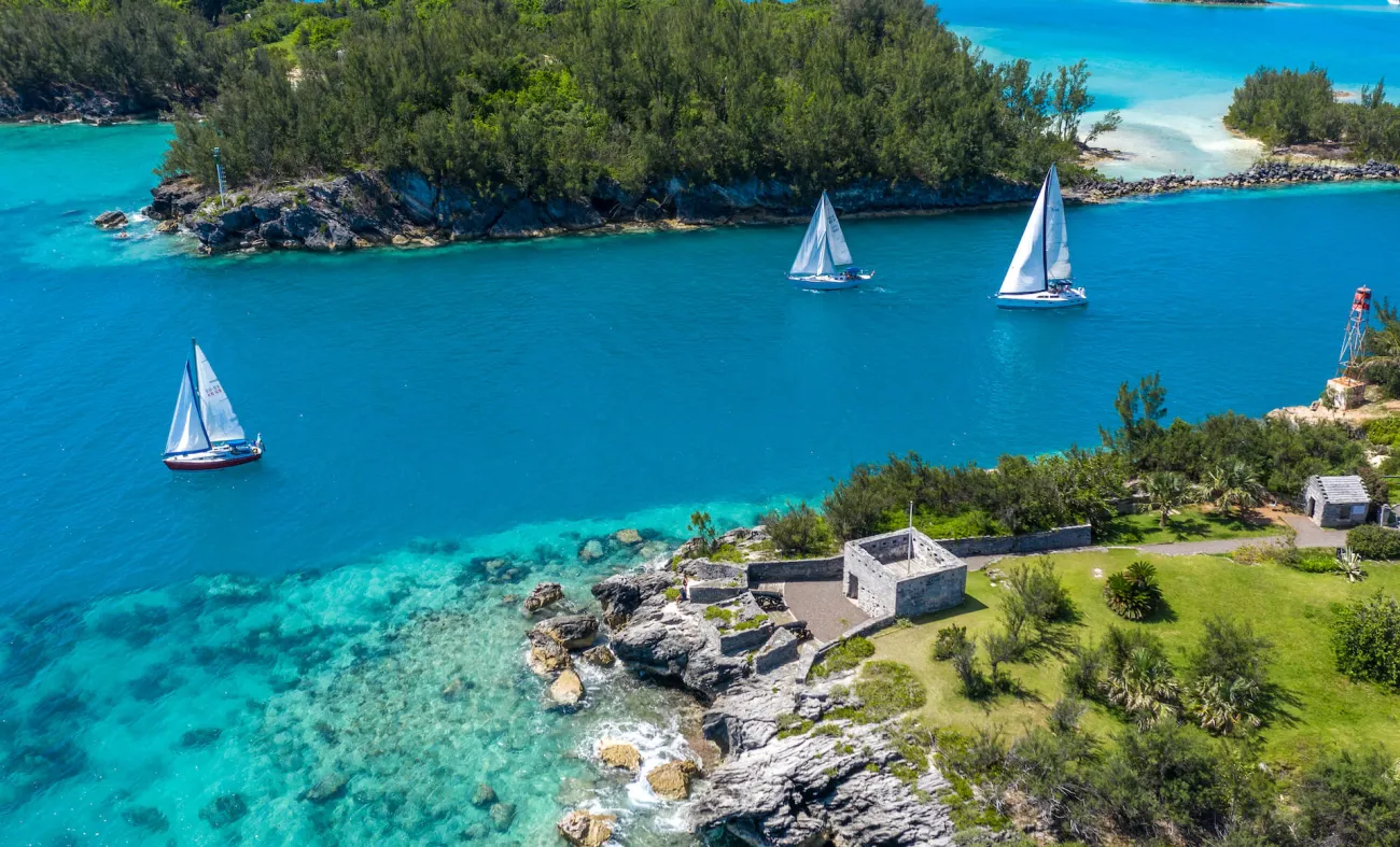 sail boats passing through a channel of water off of the coast of Bermuda