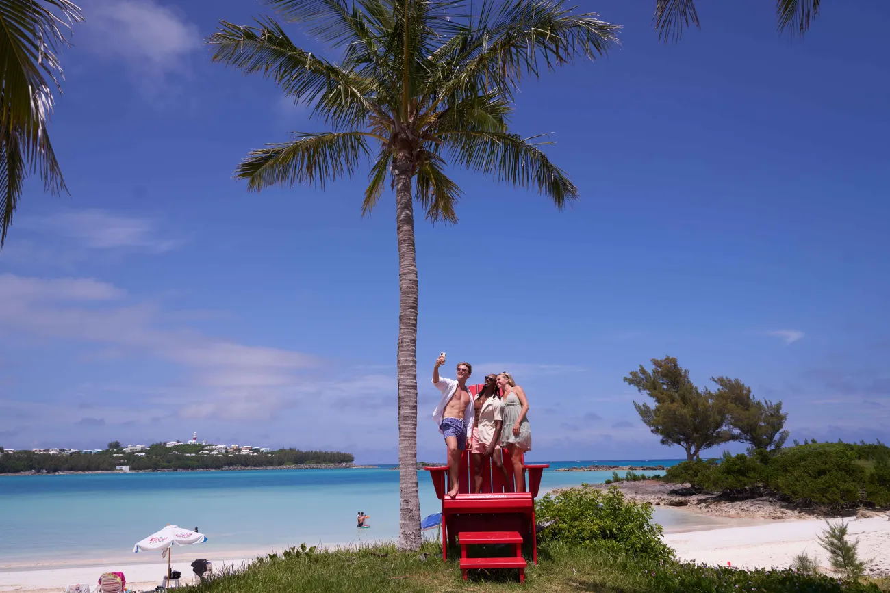 A group of friends are posing on a chair.