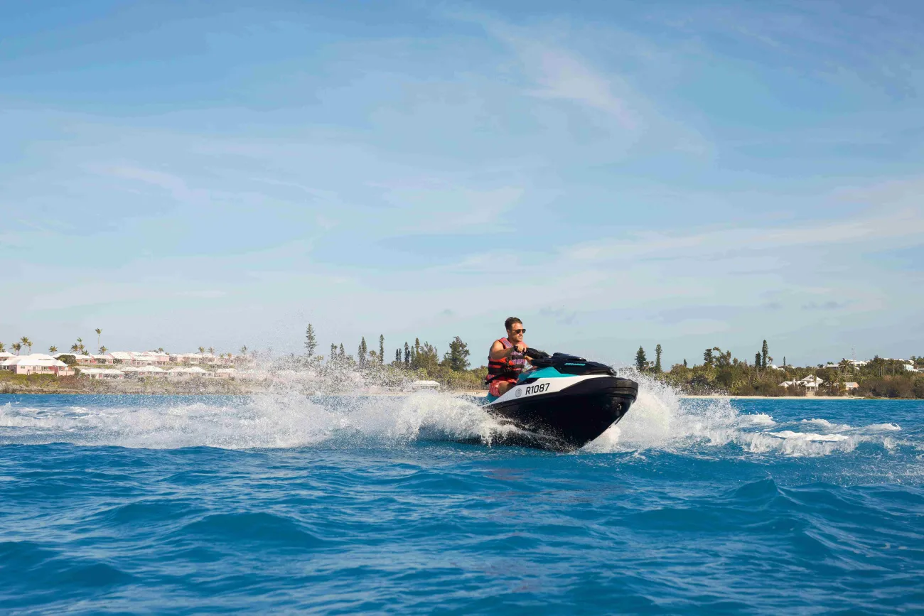 A man is riding on a jetski solo. 