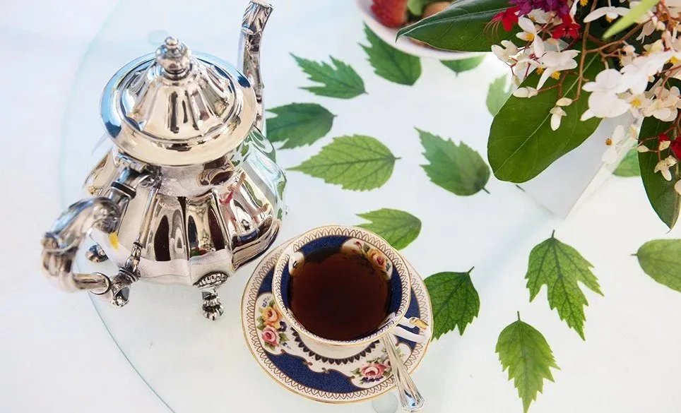 cup of tea with teapot on table