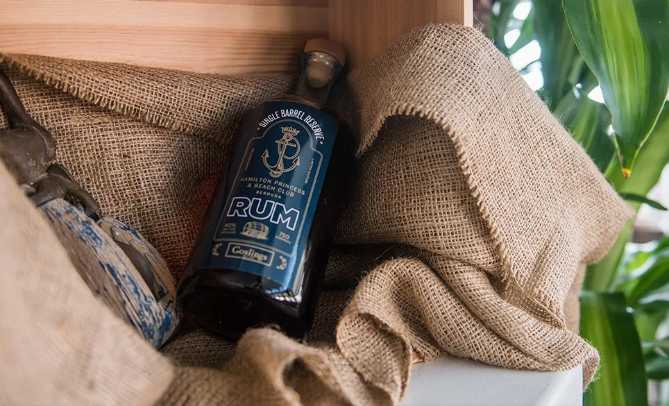 A bottle of dark rum on a burlap sack