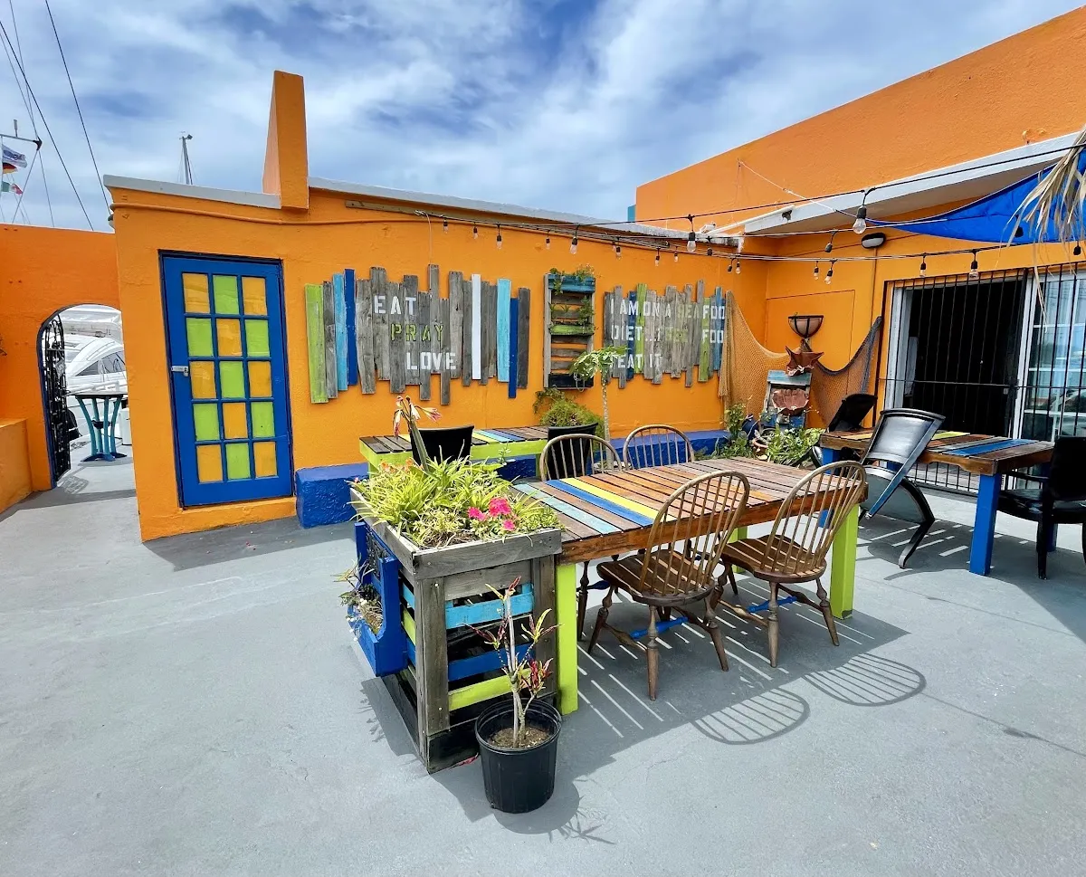 A bright orange building with an outdoor seating area.