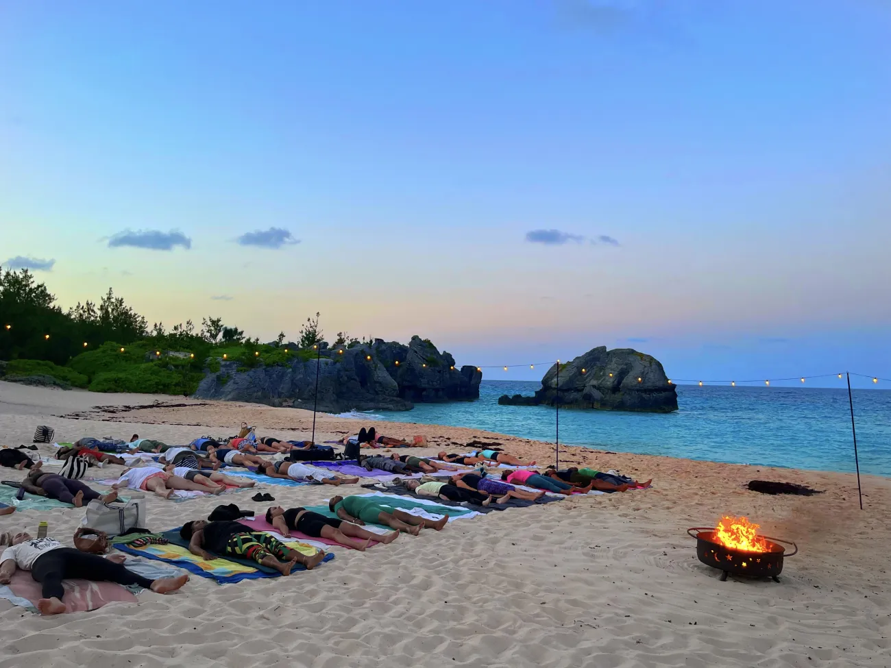 A group of people are doing yoga on the beach 