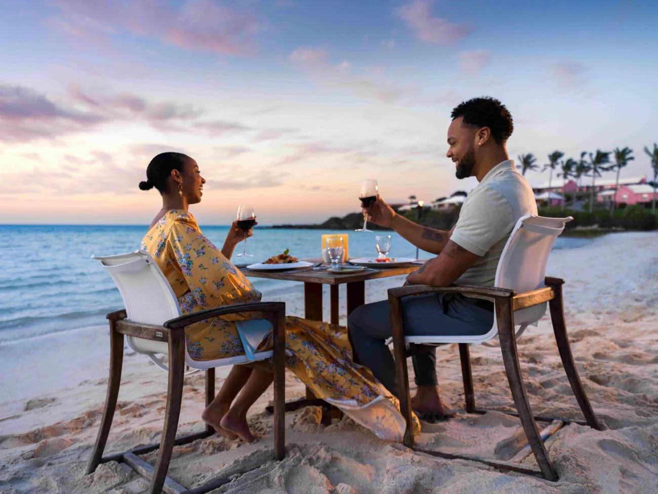A couple is making a toast on the beach.